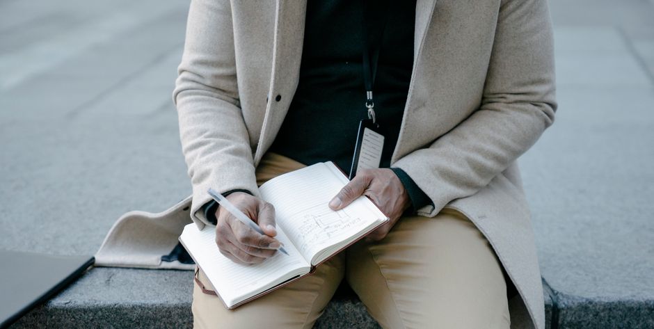 person writing notes notebook
