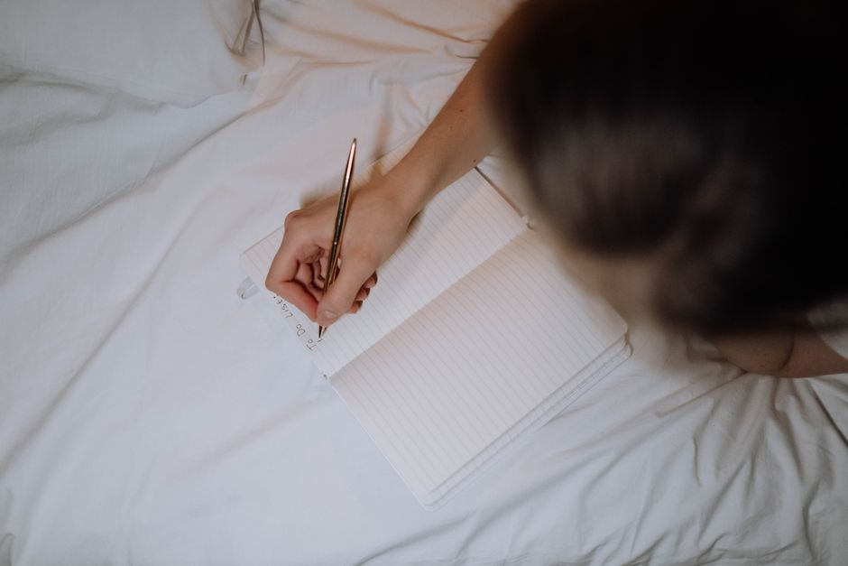 person writing notes cozy home