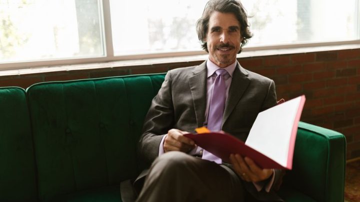 person reading paperwork couch