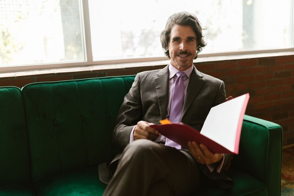 person reading paperwork couch